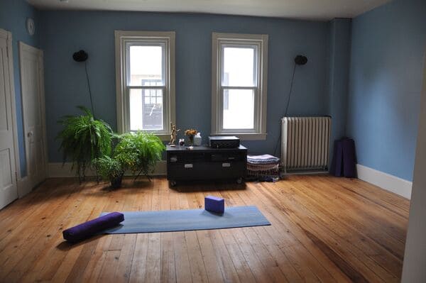 Ruhiger Raum mit sanftem Licht und einer Yogamatte